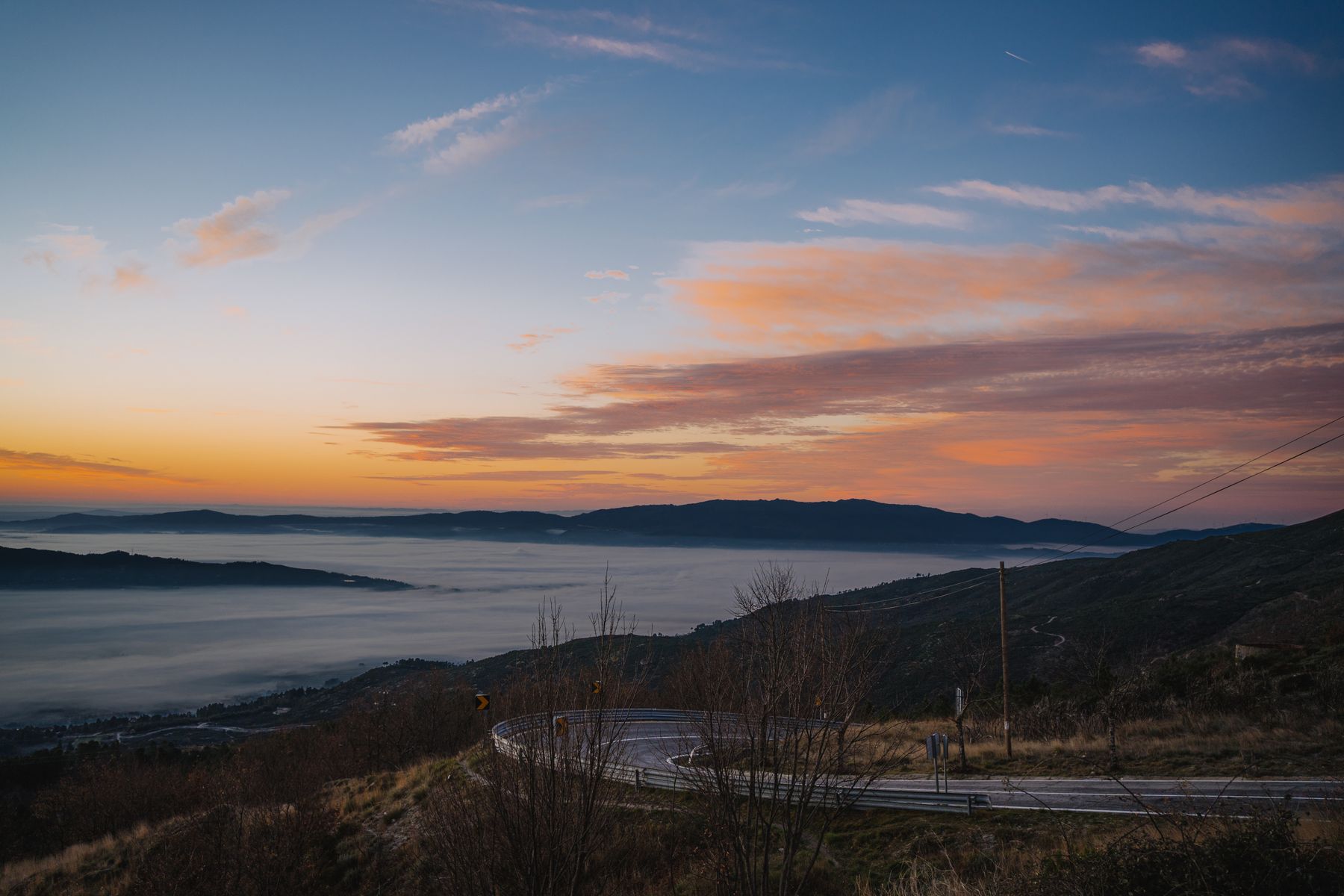 A mountain road at sunrise representing a path forward.