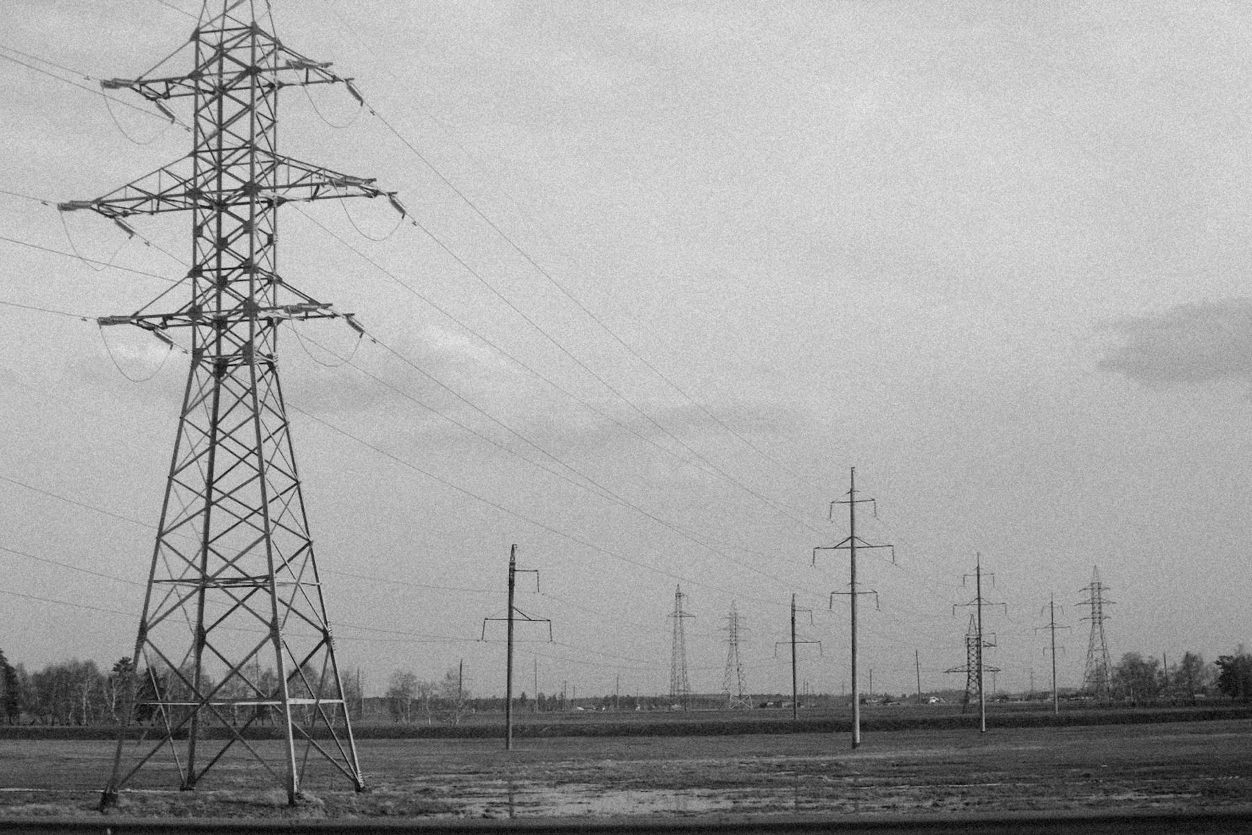 Transmission towers and electricity lines across an open landscape.